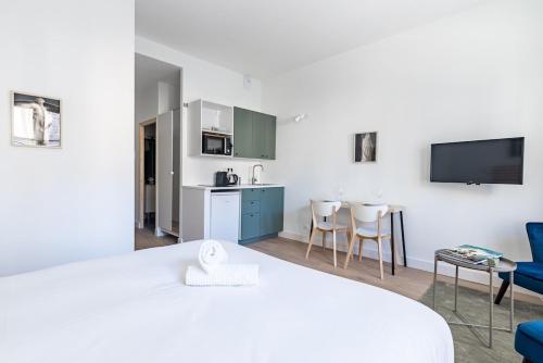 Cette chambre comprend un lit, une cuisine et une télévision. dans l'établissement Le Hardi, à Dijon