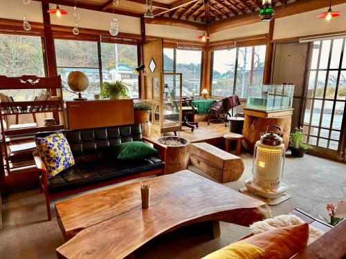 a living room with a couch and a table at 温泉付ゲストハウス Ecotone in Matsuzaki