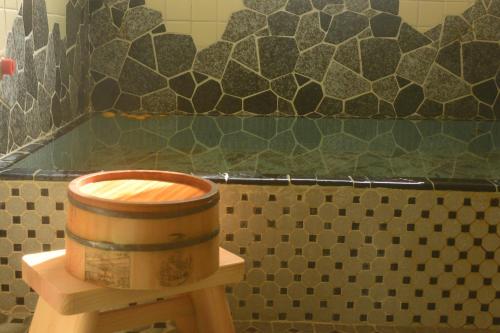 a wooden barrel sitting on top of a toilet in a bathroom at 温泉付ゲストハウス Ecotone in Matsuzaki
