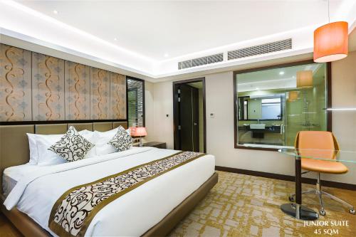 a bedroom with a bed and a glass table at Grand Sylhet Hotel & Resort in Sylhet