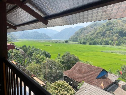 a balcony with a view of a green field at Duy Tuyen Ba Be Homestay in Bak Kan