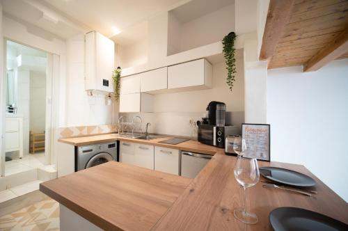 - une cuisine avec un comptoir en bois et des verres à vin dans l'établissement Appartement tout equipé 4 couchages à 600m de la Plage des Catalans, à Marseille