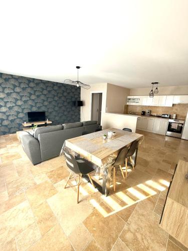 un salon avec une table en bois et un canapé dans l'établissement Le Petit Phuket - Appartement confortable et calme - Proche de toutes commodité - Stationnement facile à proximité, à Saint-Laurent-sur-Saône