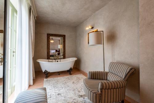 a bathroom with a tub and a chair and a couch at Villa Petriolo - Small Luxury Hotels of the World in Cerreto Guidi