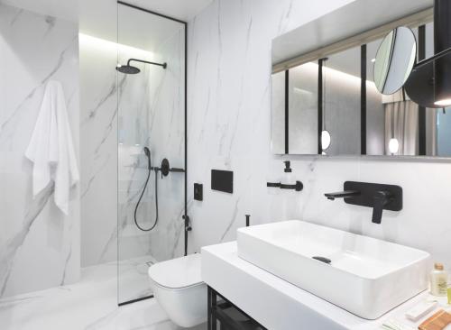 a white bathroom with a sink and a shower at The Residence Christokopidou Hotel & Spa in Athens