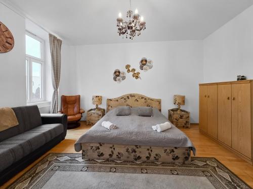 a bedroom with a bed and a couch and a chandelier at Three-Bedroom Sanctuary, King-Size Beds in Vienna