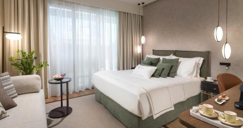 a bedroom with a large bed and a living room at The Residence Christokopidou Hotel & Spa in Athens