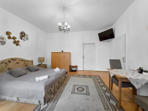 a bedroom with a bed and a table and a television at Three-Bedroom Sanctuary, King-Size Beds in Vienna