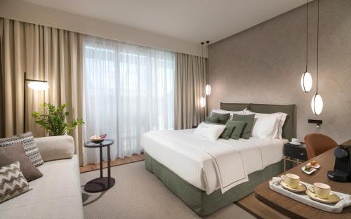 a bedroom with a large bed and a living room at The Residence Christokopidou Hotel & Spa in Athens
