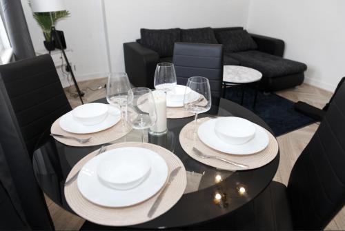 una mesa negra con platos blancos y copas de vino en 30C Rectory Road, en Oxford