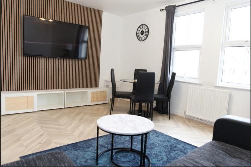 sala de estar con mesa y TV de pantalla plana en 30C Rectory Road, en Oxford