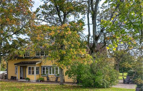 a yellow house with a tree in front of it at 4 Bedroom Awesome Home In Jönköping in Jönköping