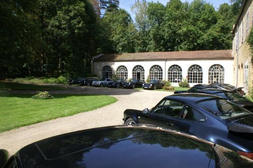 a car parked in front of a building with parked cars at B&B Vassy Etaule in Avallon