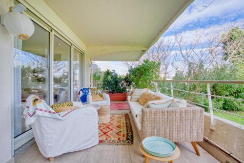 Il dispose d'une terrasse couverte avec un mobilier blanc et d'un balcon avec des fenêtres. dans l'établissement Mon Eden au soleil de Saint-Tropez, à Saint-Tropez