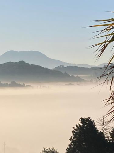 a view of a foggy lake with mountains in the background at Kokkini Peach Budget in Kokkínion