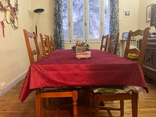 a dining room table with a red table cloth on it at Chez Mimi in Ornolac-Ussat-les-Bains