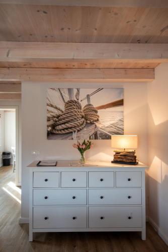 a white dresser in a room with a painting on the wall at Netzschuppen in Fehmarn