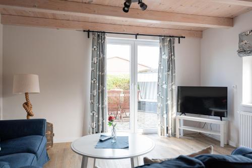 a living room with a blue couch and a tv at Netzschuppen in Fehmarn