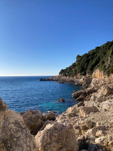 a rocky shoreline with the ocean on a clear day at Kokkini Peach Budget in Kokkínion