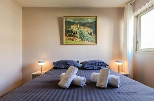 - une chambre avec un lit bleu et 2 oreillers dans l'établissement Appartement cosy Cagnes-sur-Mer, à Cagnes-sur-Mer