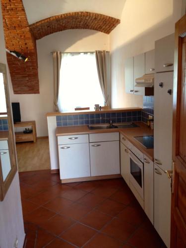 a kitchen with white cabinets and a window at Haus Ferdinand in Fernitz