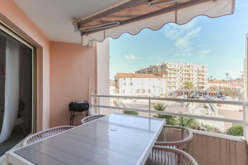d'un balcon avec une table et des chaises blanches ainsi qu'une fenêtre. dans l'établissement Appartement cosy Cagnes-sur-Mer, à Cagnes-sur-Mer