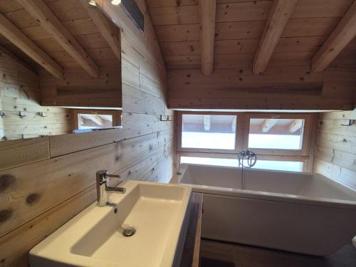 a bathroom with a tub and a white sink at La Masure Magnifique chalet - proche domaine St Foy in Sainte-Foy-Tarentaise