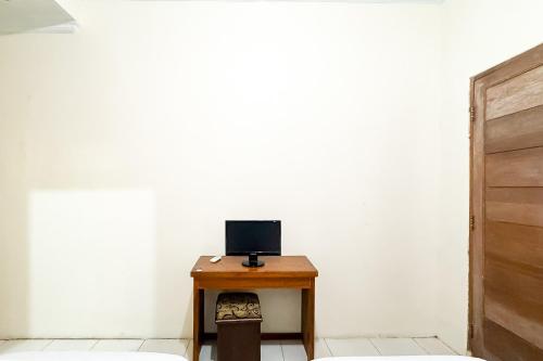 a small table with a laptop on top of it at Urbanview Hotel Sabitha Kalijati Subang in Dawuhan