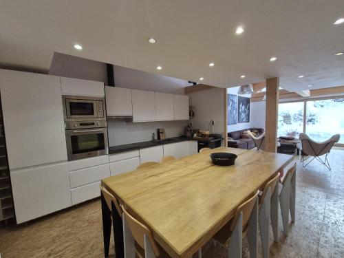 une cuisine avec une table en bois et une salle à manger dans l'établissement La Masure Magnifique chalet - proche domaine St Foy, à Sainte-Foy-Tarentaise