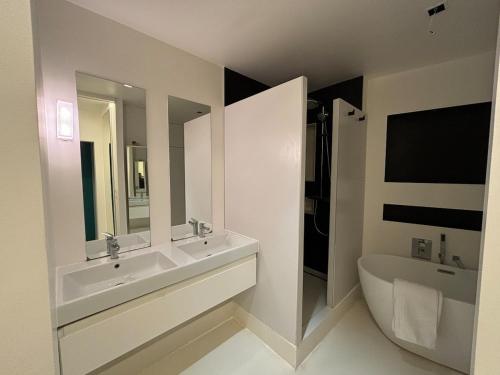une salle de bain avec deux lavabos et une baignoire et des toilettes dans l'établissement Spacious Apt Luxembourg 6 people, à Paris