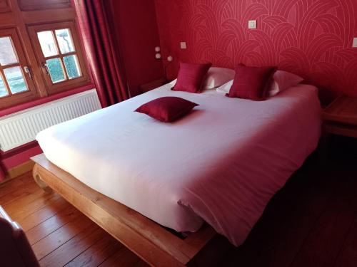 a large white bed with red pillows in a bedroom at Château-ferme de Pondrome in Beauraing