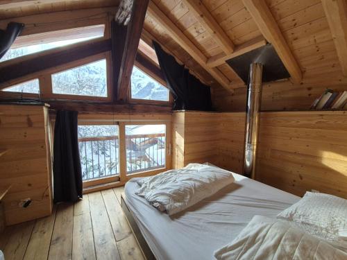a bedroom with a bed in a wooden cabin at La Masure Magnifique chalet - proche domaine St Foy in Sainte-Foy-Tarentaise