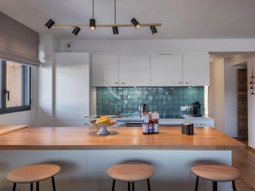 - une cuisine avec un comptoir en bois et des tabourets dans l'établissement Soldanelles A12 - Bo Immobilier Chatel, à Châtel