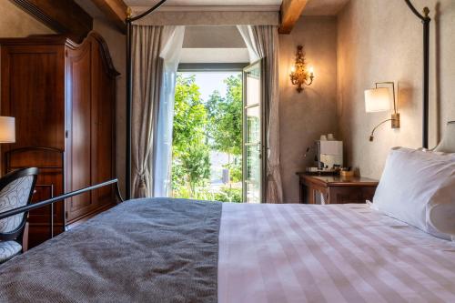 a bedroom with a bed and a large window at Villa Petriolo - Small Luxury Hotels of the World in Cerreto Guidi