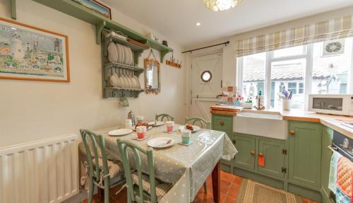 a kitchen with a table with chairs and a sink at Wheelhouse in Southwold