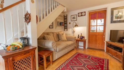 a living room with a couch and a staircase at Wheelhouse in Southwold