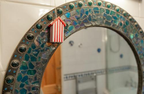a mirror with a reflection of a red and white sign at Wheelhouse in Southwold