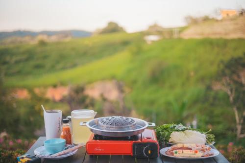 a table with a plate of food and a toaster at Florafreskhaokho in Khao Kho