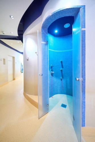 a bathroom with a shower with a person in the water at Strand- und Wellnesshotel Preussenhof in Zinnowitz