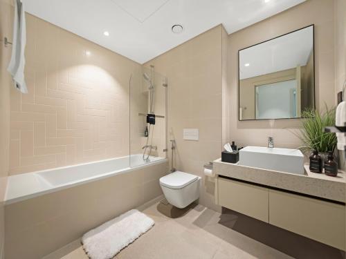 une salle de bain avec toilettes, baignoire et lavabo dans l'établissement Designer Large 1 BR with Private Beach Infinity pool in Dubai Harbour, à Dubaï