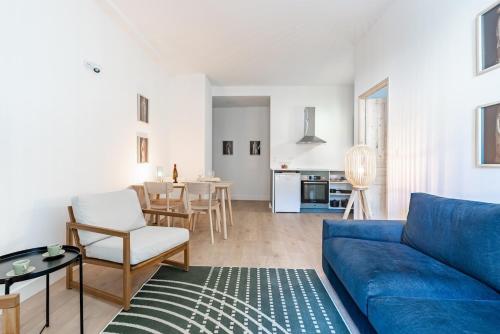 un salon avec un canapé bleu et une table dans l'établissement Le Téméraire, à Dijon