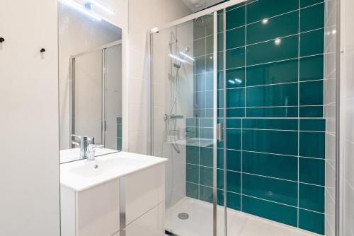une salle de bain avec une douche en verre et un lavabo dans l'établissement Le Téméraire, à Dijon
