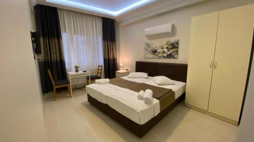 Un dormitorio con una cama, una mesa y una silla. en Hotel INNCITY, en Konak