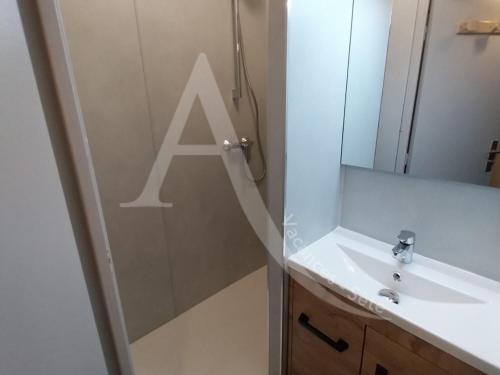 une salle de bains avec une grande lettre a sur le mur dans l'établissement Studio cabine avec loggia et terrasse, 1er ligne et vue mer pour 4 personnes, à Sète