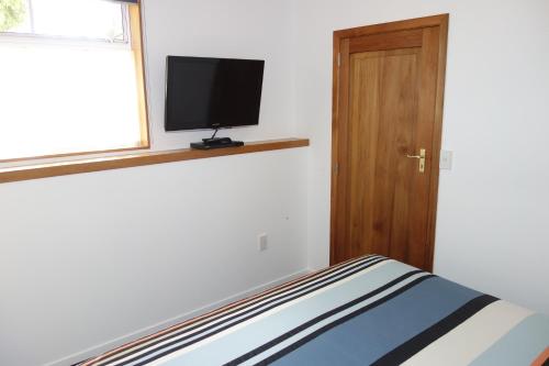 a bedroom with a bed and a television on a window at Beachside Villas Motel in Nelson