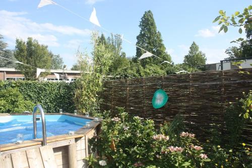 a garden with a fence and a hot tub at Modern historic home in a green setting in Hoevelaken