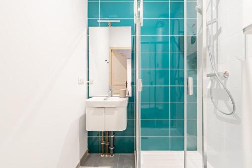 une salle de bain avec un lavabo et une douche dans l'établissement Le Valeureux - Cosy en hypercentre, à Dijon