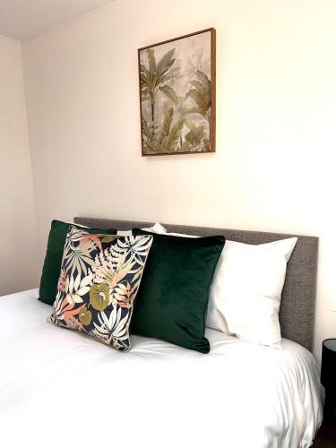 a bed with green and white pillows on it at Modern 2 Bedroom Apartment in Leicester City Centre with Free WiFi in Leicester