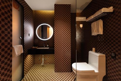 Un baño con inodoro, lavabo y espejo. en Super Time Monster Esports Hotel Shenzhen Nanshan Subway Station Branch, en Shenzhen