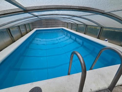 - une vue sur la piscine d'eau bleue dans l'établissement Chalet sous les sapins, calme, superbe vue avec piscine et sauna, à Gerbamont 